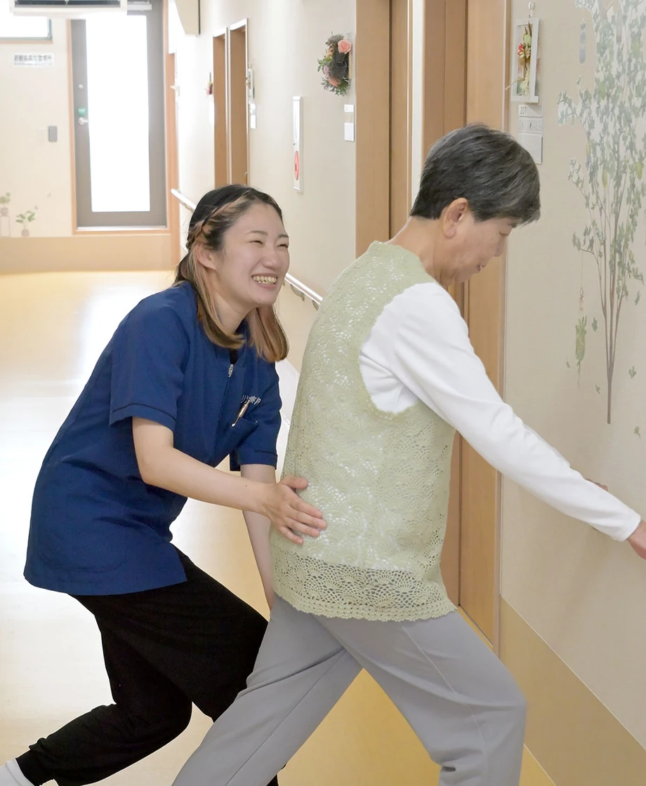 利用者様の歩行訓練を支えるスタッフ